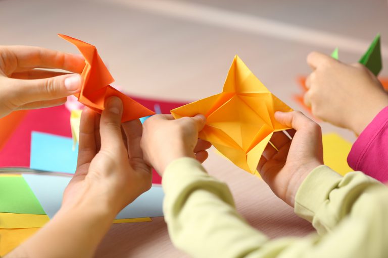 Dzieci składają origami z mamą