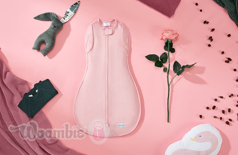 Różowy otulacz dla niemowlaka leży na stole